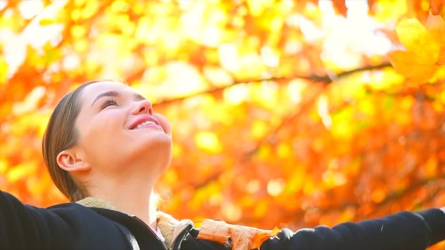 Autumn model girl spinning and laughing in autumnal park, throws colorful leaves. Beautiful Young Woman Having Fun outdoors. Fall. Red and Yellow Leaves. Beauty of Nature. Slow Motion Shot 240 fps 