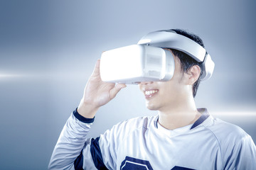 The young man wearing virtual reality goggles at the studio isolated on grey