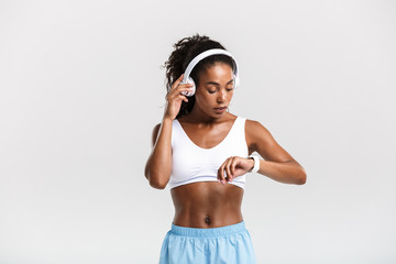 Fototapeta na wymiar Confident young fit african sportswoman listening to music