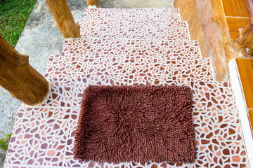 Brown door mat and staircase
