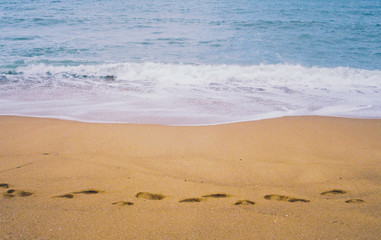 Grain Retro Film Camera Photo of Sand Beach ,high strong wave sea and blue sky with footprint on sand beach
