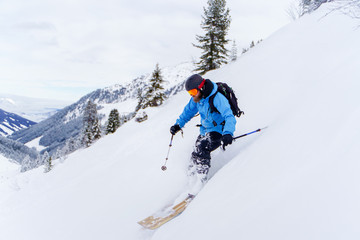 Naklejka na ściany i meble Image of athlete man with beard skiing in winter resort .