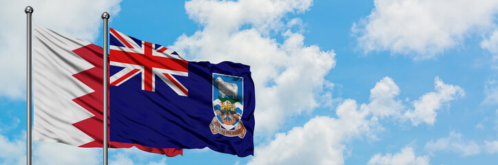 Bahrain and Falkland Islands flag waving in the wind against white cloudy blue sky together. Diplomacy concept, international relations.