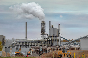 Factory chimneys (chimneys) pollute the air in a green field.  Ecological concept. Pollution....