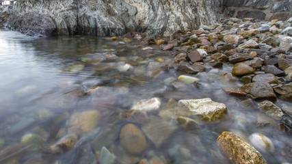 Fototapeta premium efecto del agua sobre la orilla de una playa de piedra