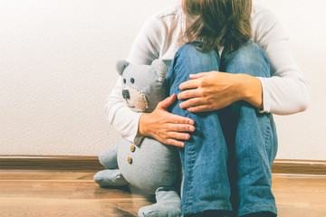 Prenatal loss concept - depressed woman holding teddy bear toy, copy space