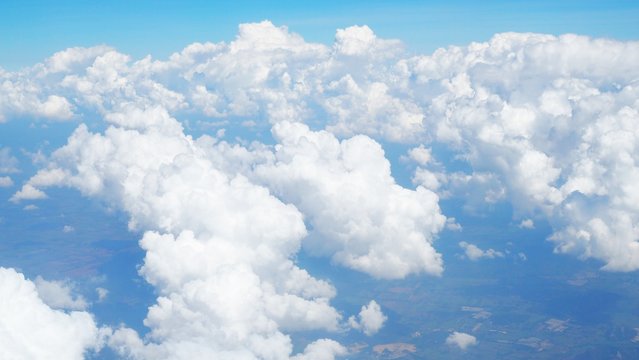 blue sky background with clouds, beautiful cloudscape, view over white fluffy clouds, freedom concept