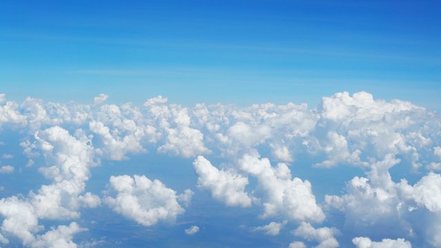 blue sky background with clouds, beautiful cloudscape, view over white fluffy clouds, freedom concept