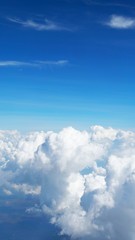 blue sky background with clouds, beautiful cloudscape, view over white fluffy clouds, freedom concept