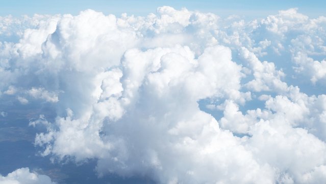 blue sky background with clouds, beautiful cloudscape, view over white fluffy clouds, freedom concept