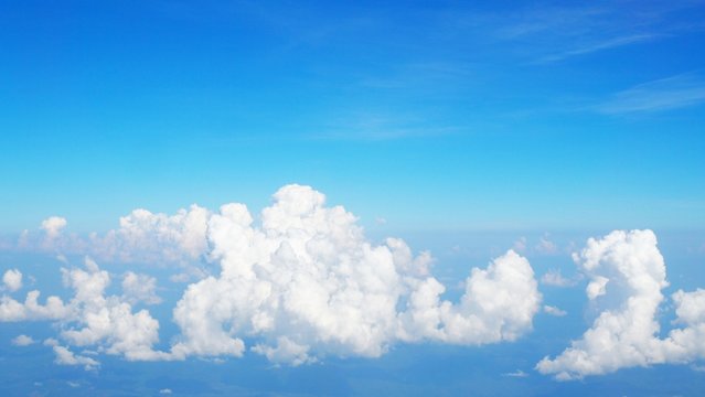blue sky background with clouds, beautiful cloudscape, view over white fluffy clouds, freedom concept