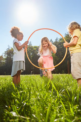 Kinder springen durch einen Gymnastik Reifen