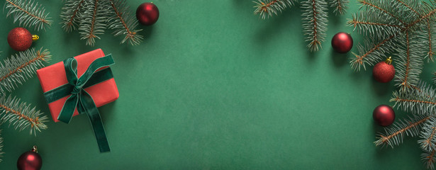 Christmas border with xmas tree and red gift on green background. Merry christmas card. Winter holiday. Happy New Year. Space for text