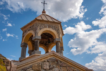 Fototapeta na wymiar Armenian Church with bell tower on the background of blue cloudy sky.