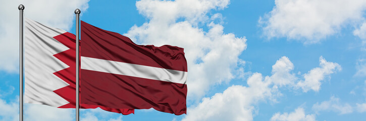 Fototapeta na wymiar Bahrain and Latvia flag waving in the wind against white cloudy blue sky together. Diplomacy concept, international relations.