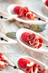 Delicious canapes hamon with raspberries. Concept of food, restaurant, catering, menu.