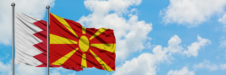 Bahrain and Macedonia flag waving in the wind against white cloudy blue sky together. Diplomacy concept, international relations.