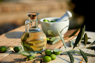 olive oil and green olive on the wooden background