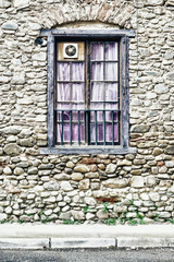 Fototapeta na wymiar Stone wall with wooden window