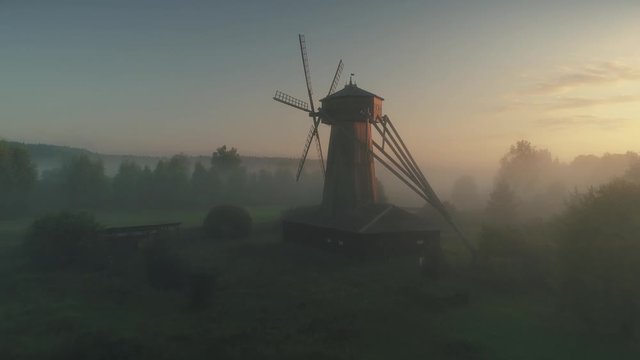 Drone approach old wooden nursery windmill beautiful lonely freestanding mill scenic before dawn natural  countryside landscape mystical fog dark forest. Historical ancient traditional architecture