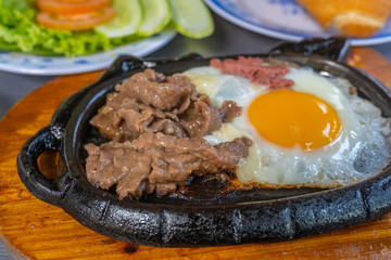 Sizzling beef steak served with sunny egg and salad