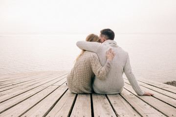 couple hugging on a pier - Powered by Adobe