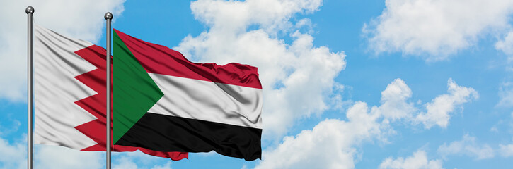 Fototapeta na wymiar Bahrain and Sudan flag waving in the wind against white cloudy blue sky together. Diplomacy concept, international relations.