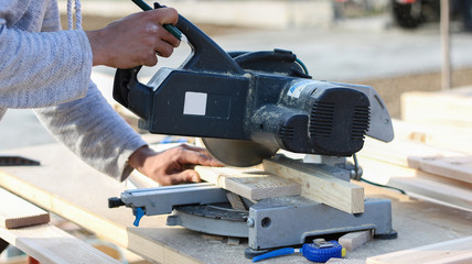 worker cutting wood with circular saw (softwood)