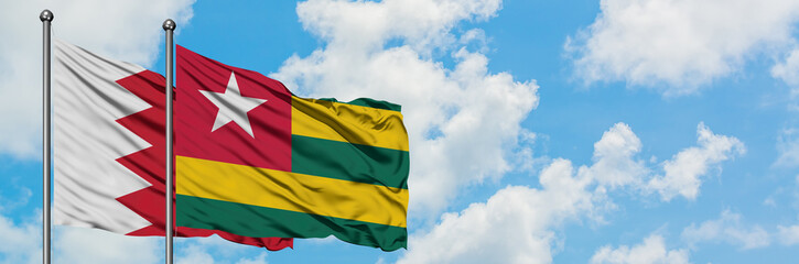 Fototapeta na wymiar Bahrain and Togo flag waving in the wind against white cloudy blue sky together. Diplomacy concept, international relations.