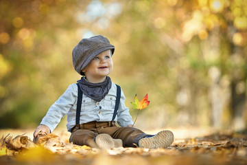 kleiner Junge lacht, spielt im Herbst