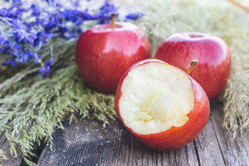 Ripe juicy red apples lie on a wooden table. Vitamins and a healthy diet. Vegetarian concept.