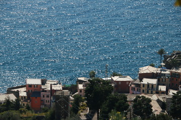 Village of Vernazza with the houses perched on the hill overlooking the blue sea of the Cinque Terre.