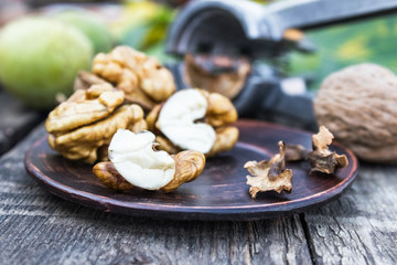 Obraz na płótnie Canvas Walnuts and walnut kernels lie on a bowl on a rustic old wooden table. Walnut kernels.