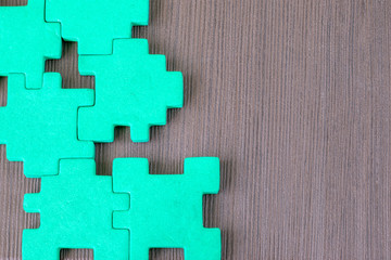 Obraz premium green puzzle on a wooden surface