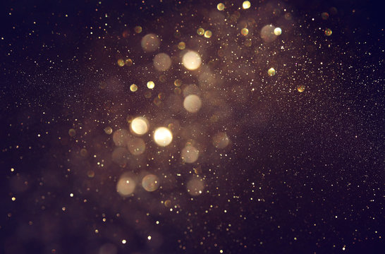 background of abstract glitter lights. gold and black. de focused