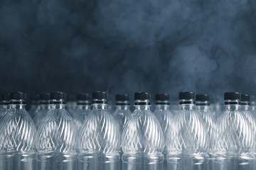 empty plastic bottles on black background with smoke, pollution concept