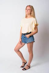 Full body shot of happy young beautiful blonde woman thinking