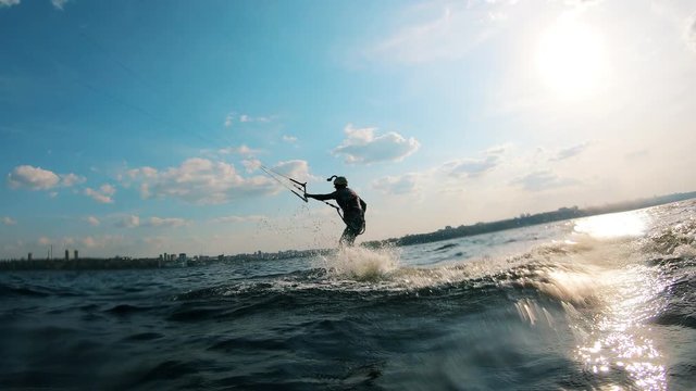Sportsman kite surfing on water.