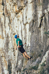 Fototapeta premium Man with a rope engaged in the sports of rock climbing on the rock.
