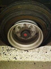 Replacement of a flat tire on a highway truck semitrailer.Removed tire from wheel disc on truck. Tire puncture on highway.