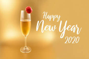 Happy New Year 2020 images. Glass with champagne on a golden background. Festive golden background. New Year toast. Champagne with strawberry. Happy New Year 2020 Sign