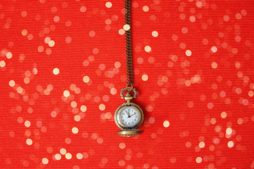 Minimalism. Vintage pocket watch on chain on red background. New year. Christmas. The dial of the...