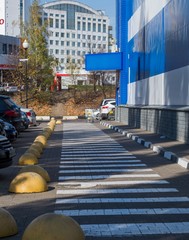 A pedestrian crossing separated from the car Park by stone hemis