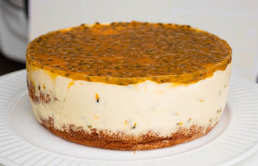 Passion fruit biscuit cake with cream cheese filling and jelly like fruit coulis top, homemade cake on the plate.
