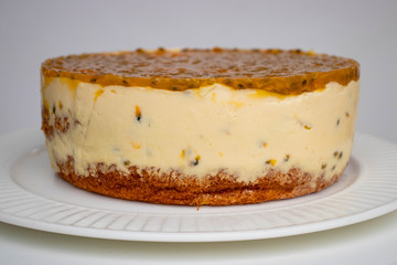 Passion fruit biscuit cake with cream cheese filling and jelly like fruit coulis top, homemade cake on the plate.