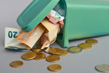 closeup of Euro banknotes and coins in the garbage can