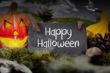Black slate chalkboard with happy halloween pumpkin decoration with fog and cemetery