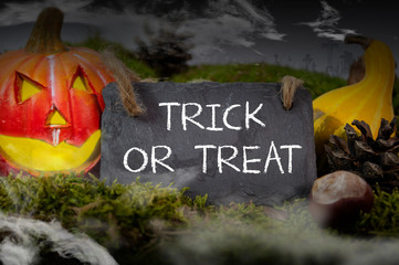 Black slate chalkboard with happy halloween pumpkin decoration with fog and cemetery