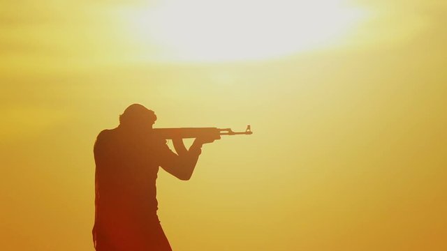 warrior with Kalashnikov at sunset day. fighter is training with a machine gun at sunset.