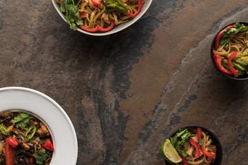 top view of tasty spicy thai noodles with chopsticks on stone surface